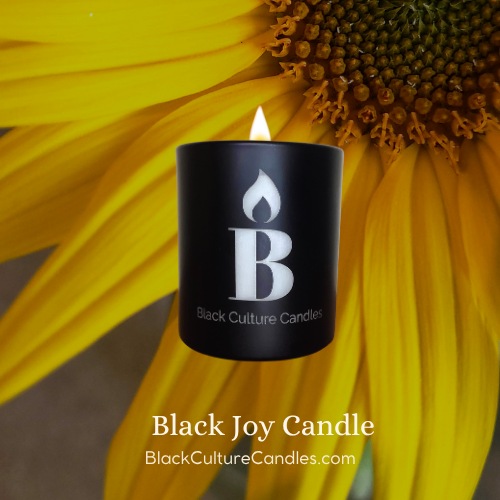 Black Culture Candles Black Joy 8oz matte black etched glass candle lit against a sunflower background