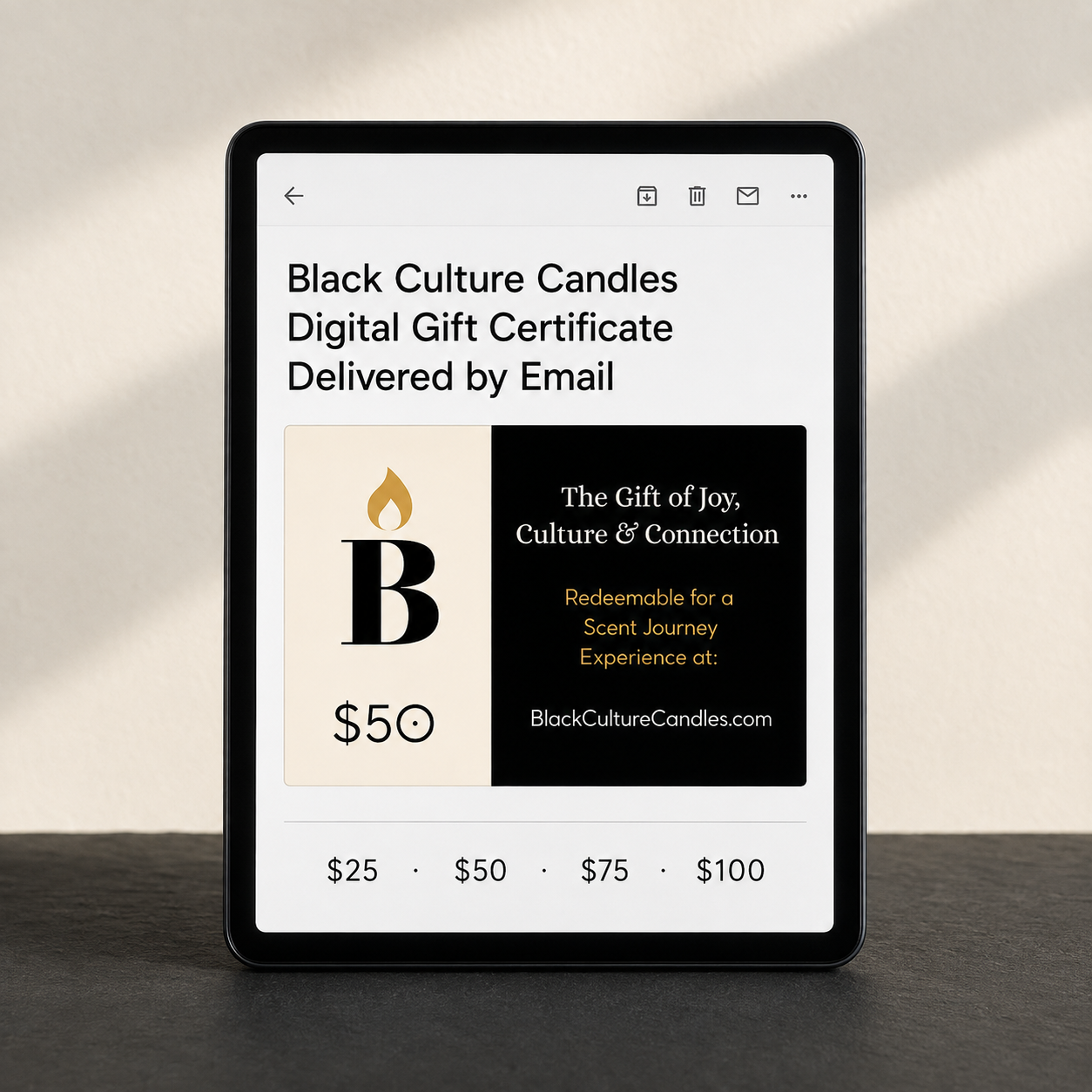A tablet device on a dark surface against a light wall, displaying a Black Culture Candles digital gift certificate design with price options at the bottom.