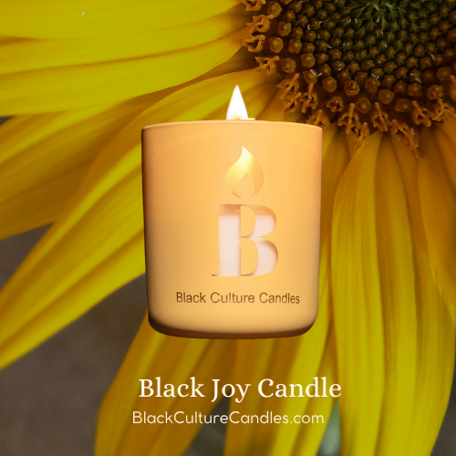 Black Culture Candles Black Joy 13oz matte yellow etched glass candle lit against a sunflower background