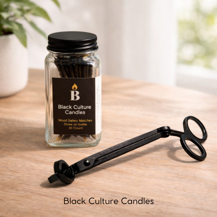 Black Culture Candles candle accessory set with wood safety matches in a glass jar and black metal wick trimmer on a wooden table.