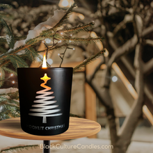 Load image into Gallery viewer, Moonlit Christmas candle in a sleek matte black jar with an etched pine tree design that glows like a Christmas tree when lit. A luxurious candle inspired by holiday magic, featuring notes of Christmas pine, soft floras and amber. #Moonlit Christmas #HolidayMagic #LuxuryCandles #BlackCultureCandles #ScentJourney #ChristmasVibes #LimitedEditionCandles #WinterNostalgia #HolidayDecor #ChristmasGifts #HolidayScent #ElegantCandles #BlackOwnedBusiness #SeasonalScents
