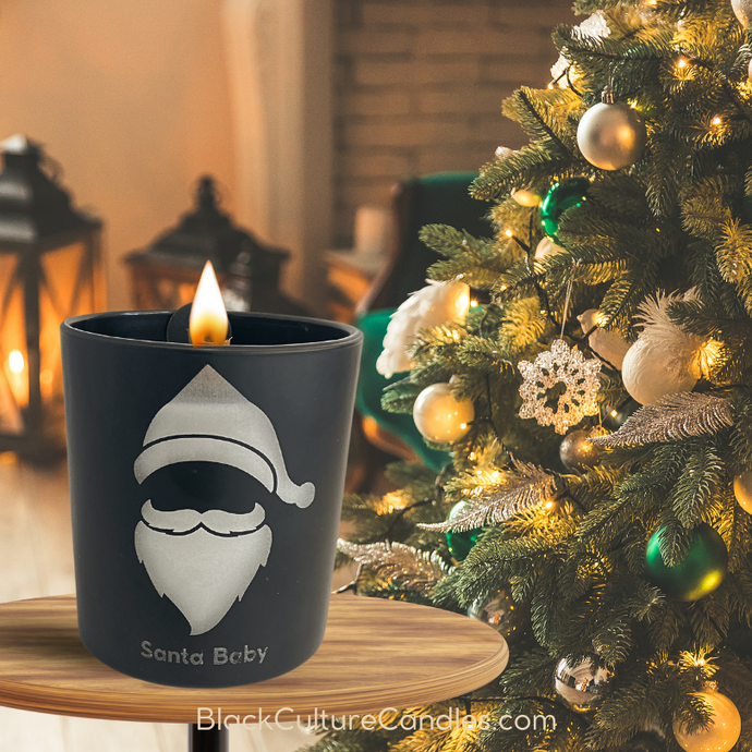 Black Culture Candles Santa Baby candle in black matte glass with Santa's hat and beard etched on, featuring holiday scent notes of red wine, winter berries, #absinthe, #jasmine and #holly. #SantaBaby #HolidayVibes #Christmas Candles #FestiveSeason #HolidayDecor #BlackSanta #ChristmasParty #HolidayMagic #RedWine