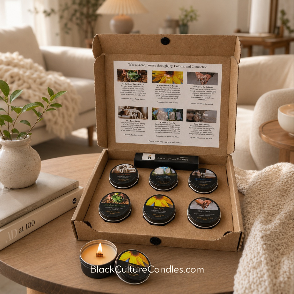 Black Culture Candles Scent Journey Sampler styled in a warm, intentional home setting with six artisan candle tins and one lit wood wick candle for scent discovery. 