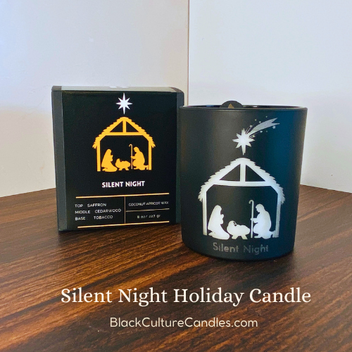Silent Night Candle by Black Culture Candles® — a luxury artisan Christmas candle in etched matte black glass with a delicate nativity design. Handcrafted with a shimmering vegan coconut-apricot wax blend and a sustainably sourced crackling wood wick, this reflective holiday scent features saffron, cedar, vetiver, amber, tobacco, and myrrh for a warm, timeless fragrance that captures the calm and stillness of Christmas Eve.