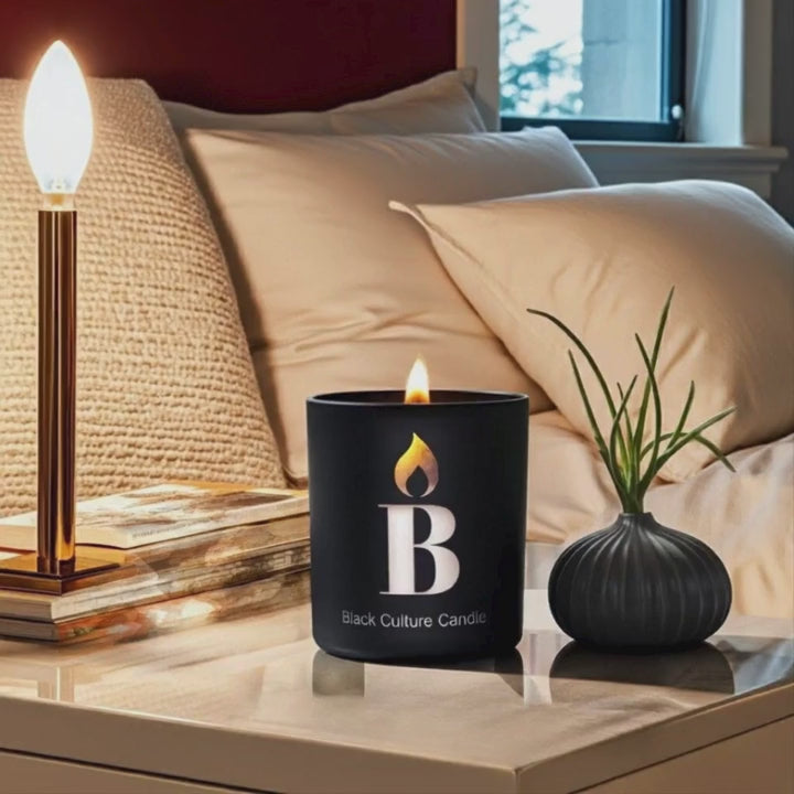 Black Love candle by Black Culture Candles burning in an etched glass vessel with a crackling wood wick.