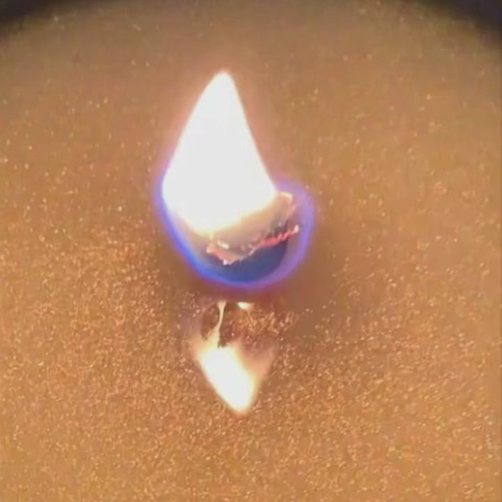 Close-up of a wood wick candle flame burning in coconut apricot wax by Black Culture Candles.