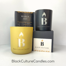 Load image into Gallery viewer, Black Joy luxury scented candle in etched glass with notes of citrus, pineapple, and amber—handcrafted with non-toxic wax and a crackling wood wick. A vibrant scent inspired by Black cultural joy, sunshine, and connection.

